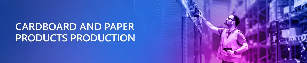 Напис “Cardboard and Paper Products Production” на синьому фоні і справа чоловік на складі готової паперово=картонної проукції
